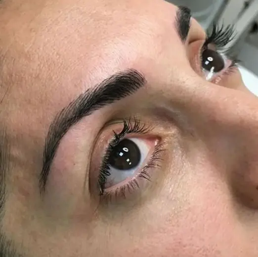 Primer plano de ojo con ceja gruesa y definida