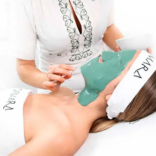 Client relaxing with a green purifying mask during a deep cleansing facial in Málaga