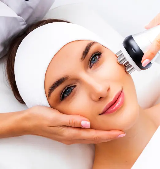 Smiling woman receiving facial radiofrequency on her cheek